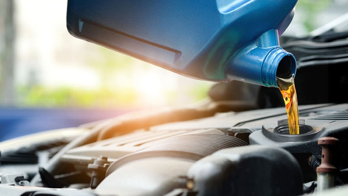 pouring oil into car engine
